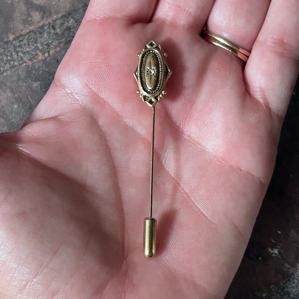 Avon gold-toned hat pin with a rhinestone,
